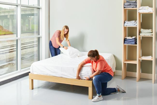 kaksi naista lepäämässä sänkyä valkoisilla lakanoilla