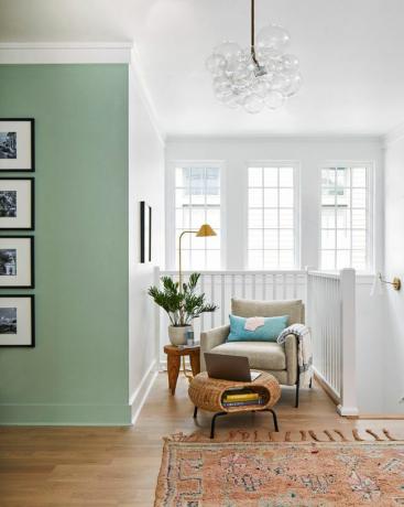 Markkinointi Real Simple Home 2022 2nd Floor Landing, vihreä maali korostusseinässä tuolilla ja ottomaanilla